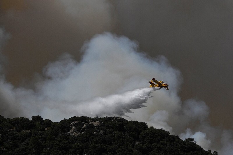 Un avión arroja agua sobre un incendio forestal en las afueras de Cenicientos, en el centro de España, ya que España fue azotada por más incendios forestales en medio de altas temperaturas